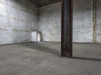 an empty warehouse with some white walls and concrete floors for storage space, and a door for the entry