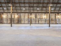 an empty industrial warehouse with a concrete floor and exposed ceilings, including the ceiling beams