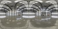 a very large and reflective building with some lights on the floor as seen through an angled circular mirror