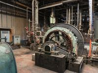 a large industrial machine inside of a factory where some workers work on their equipment,