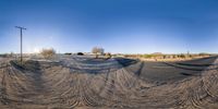 a fish eye view of a person riding a motorcycle on a dirt road near trees