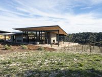 an elevated area with grass and rocks at the winery building overlooking wineries in the valley