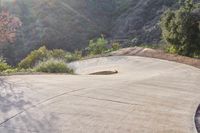 the sun is setting behind a hill behind a stop sign with a large rock face