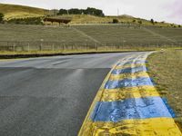 this is a yellow and blue painted line along the road in front of a hillside