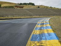 this is a yellow and blue painted line along the road in front of a hillside