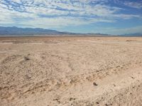 a man sitting on the ground in the desert while looking at the camera with no one around him