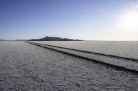 the road goes long and empty on the desert, with mountains in the distance in the distance