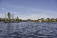 an empty lake surrounded by many buildings and boats in the water with mountain in the background