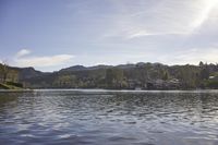 an empty lake surrounded by many buildings and boats in the water with mountain in the background