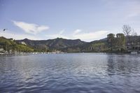 an empty lake surrounded by many buildings and boats in the water with mountain in the background