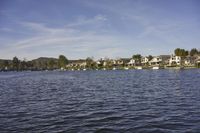 an empty lake surrounded by many buildings and boats in the water with mountain in the background