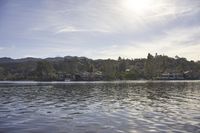 an empty lake surrounded by many buildings and boats in the water with mountain in the background
