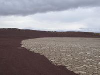 the ground is cracked and barren in a desert area with a few rocks at it