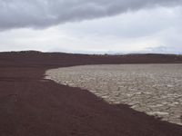 the ground is cracked and barren in a desert area with a few rocks at it