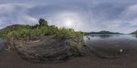 a big rock by a small body of water with land behind it in a large round