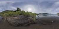 a big rock by a small body of water with land behind it in a large round