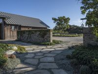 a home with stone stepping around the front yard and the large door leading to the front yard