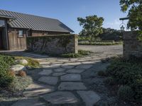 a home with stone stepping around the front yard and the large door leading to the front yard