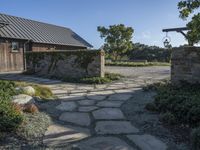 a home with stone stepping around the front yard and the large door leading to the front yard