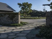 a home with stone stepping around the front yard and the large door leading to the front yard