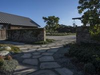 a home with stone stepping around the front yard and the large door leading to the front yard