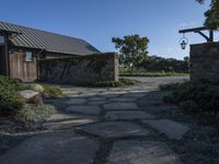 a home with stone stepping around the front yard and the large door leading to the front yard