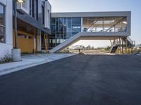 a modern building has large stairs on it in the middle of a city street, near some trees