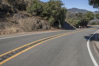 a mountain road going through the hills with a sign above it that reads the turn in on the right