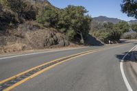 a mountain road going through the hills with a sign above it that reads the turn in on the right