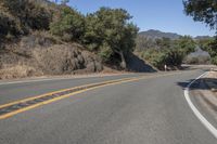 a mountain road going through the hills with a sign above it that reads the turn in on the right