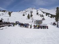 the group of people are on the slope outside of the lodge on the mountain with skis and snowboards