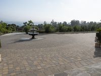 some black statues standing on a paved patio with trees in the background and a view out