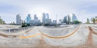 a blurry picture of a large skateboarding ramp with buildings in the background and a person on a skateboard