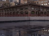 a large building with a reflection on the pavement in the street behind it, a reflection of the building