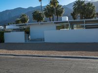 a car is parked in front of a modern building with mountains in the background on a clear day