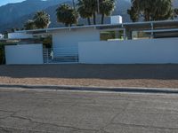 a car is parked in front of a modern building with mountains in the background on a clear day