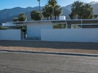 a car is parked in front of a modern building with mountains in the background on a clear day