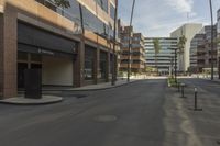 a empty street that has buildings on it in a big city with palm trees along the sidewalk