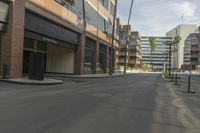 a empty street that has buildings on it in a big city with palm trees along the sidewalk
