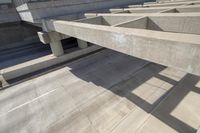 concrete ramps with a long, straight walkway between them on the same side and a bridge over them on the other side