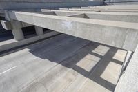 concrete ramps with a long, straight walkway between them on the same side and a bridge over them on the other side