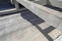 concrete ramps with a long, straight walkway between them on the same side and a bridge over them on the other side