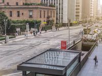 an empty city street with people walking by at the sidewalk and one person crossing the street