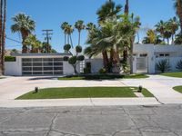 a street view of a garage and trees in the background of a white home in palm springs, florida