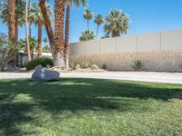 a stone that looks like a rock sits by the curb of a driveway in palm springs