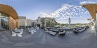 a panoramic view of patio seating with furniture and sun umbrellas in background