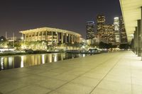 an area of buildings and a body of water at night with lights shining on them