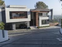 the exterior and landscape of a modern house in los angeles, california with stone and wood