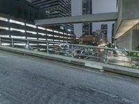 night time city street with large buildings and a bridge in the middle of it underpass