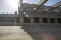 the sun is shining on some concrete buildings as seen from the street below the ramp